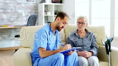医生助理在听养老院的老退休妇女讲话时在剪贴板上做笔记